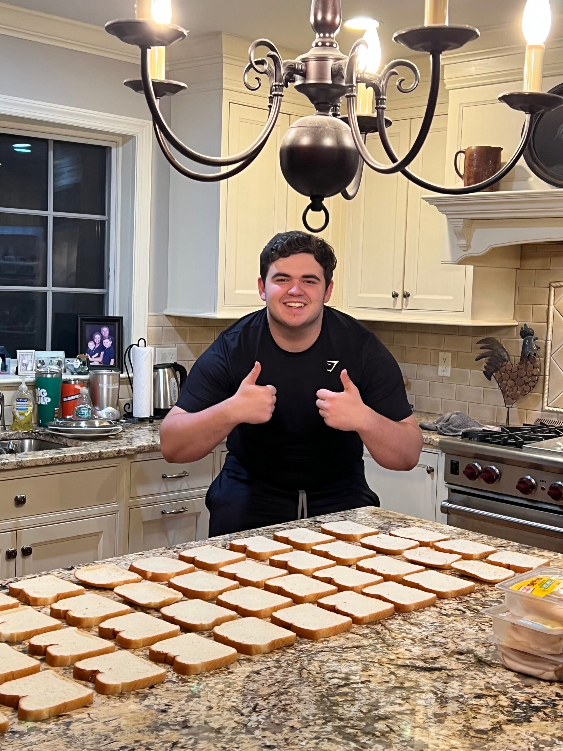 a young man posing in front of some sandwiches