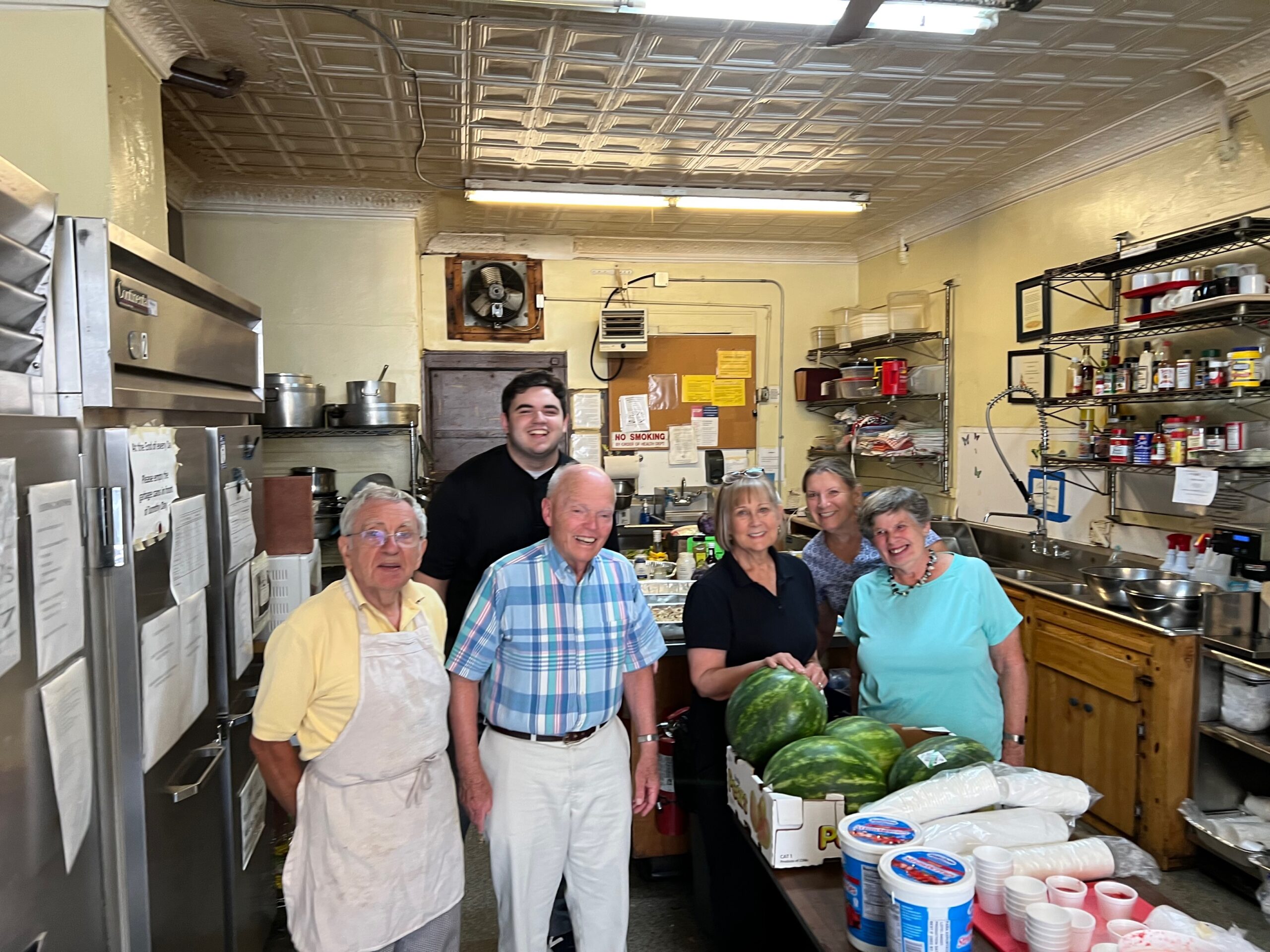 a young man posing with the volunteers at a hospitality