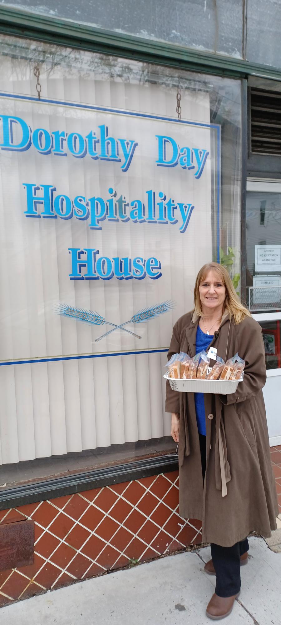 A woman standing in front of a hospitality house